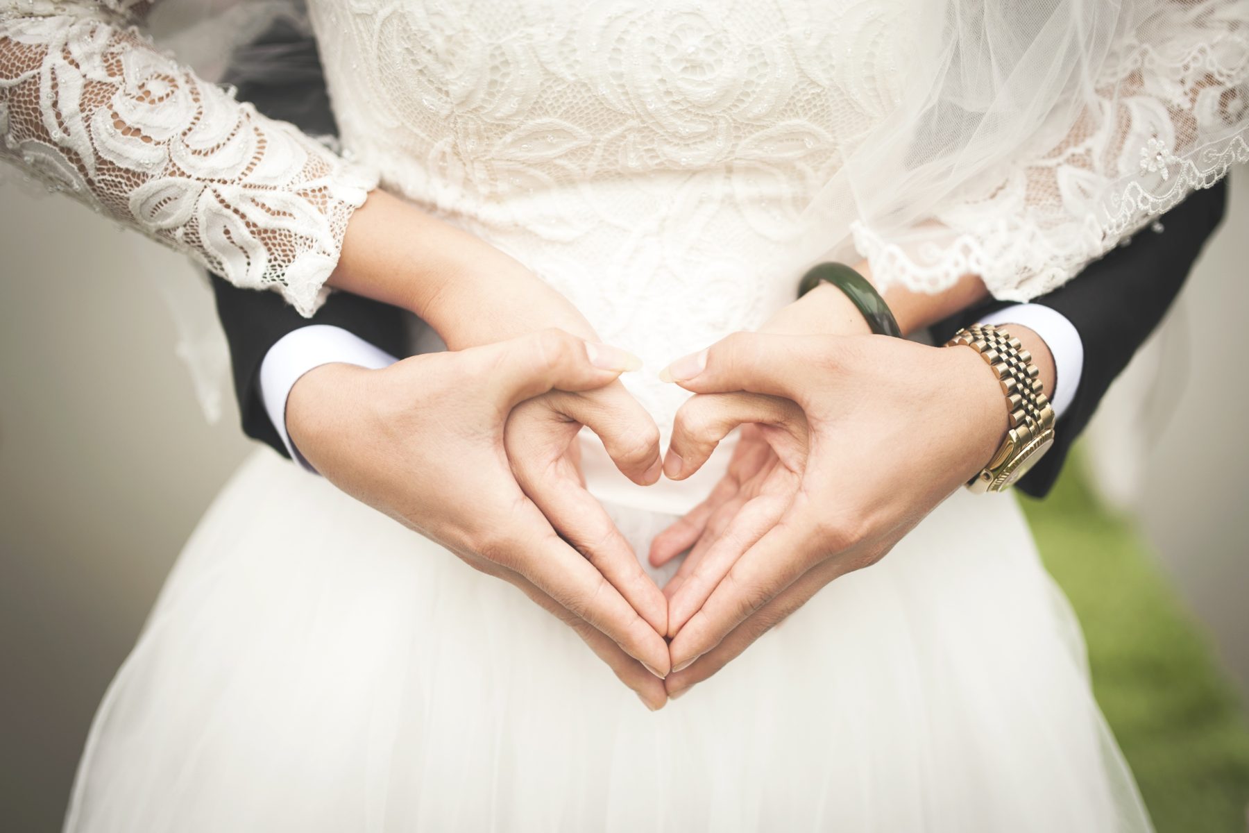 Wedding couples hands creating shape of a heart