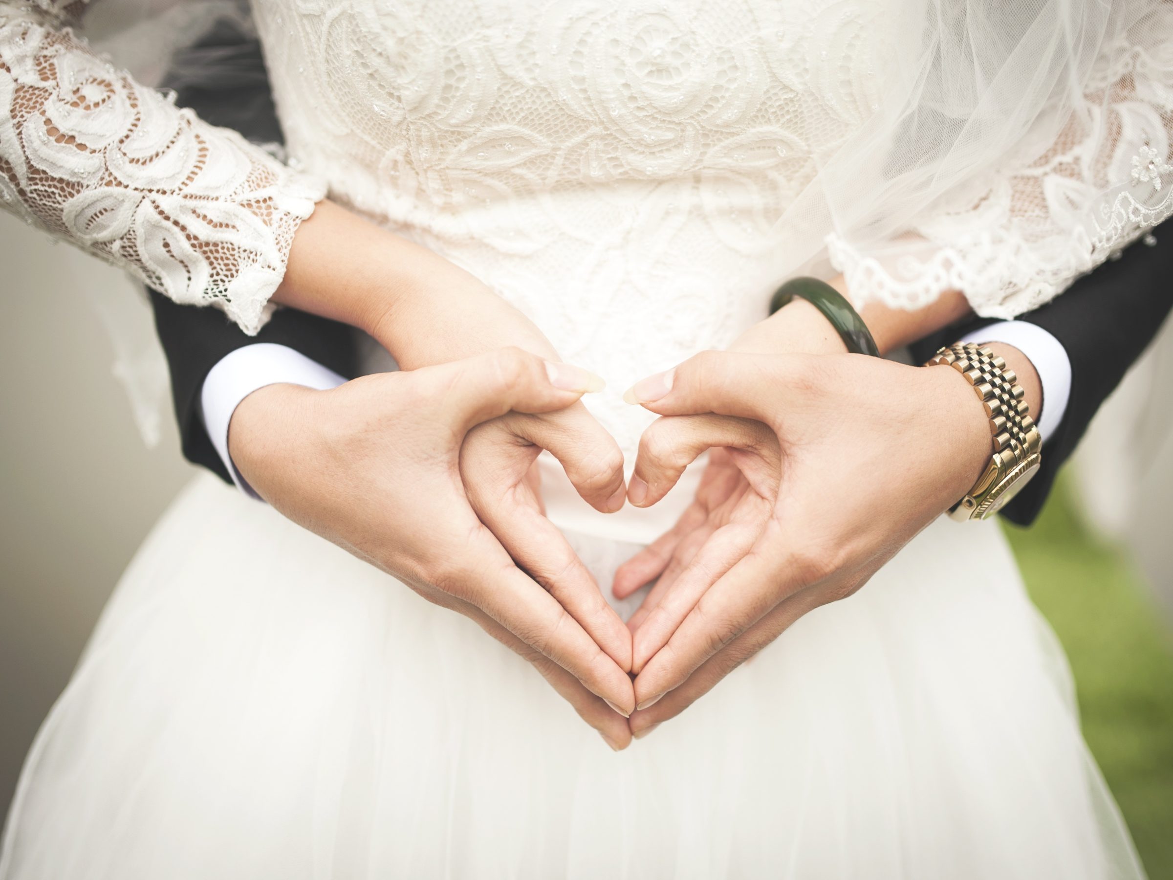Wedding couples hands creating shape of a heart